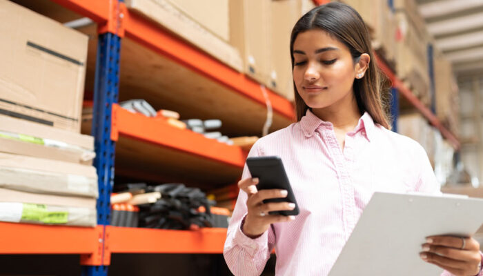 Woman looking at phone in warehouse