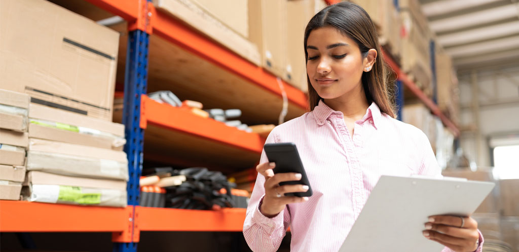 Woman looking at phone in warehouse